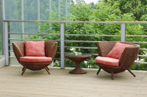 Wicker chairs on the patio in a beautiful garden.